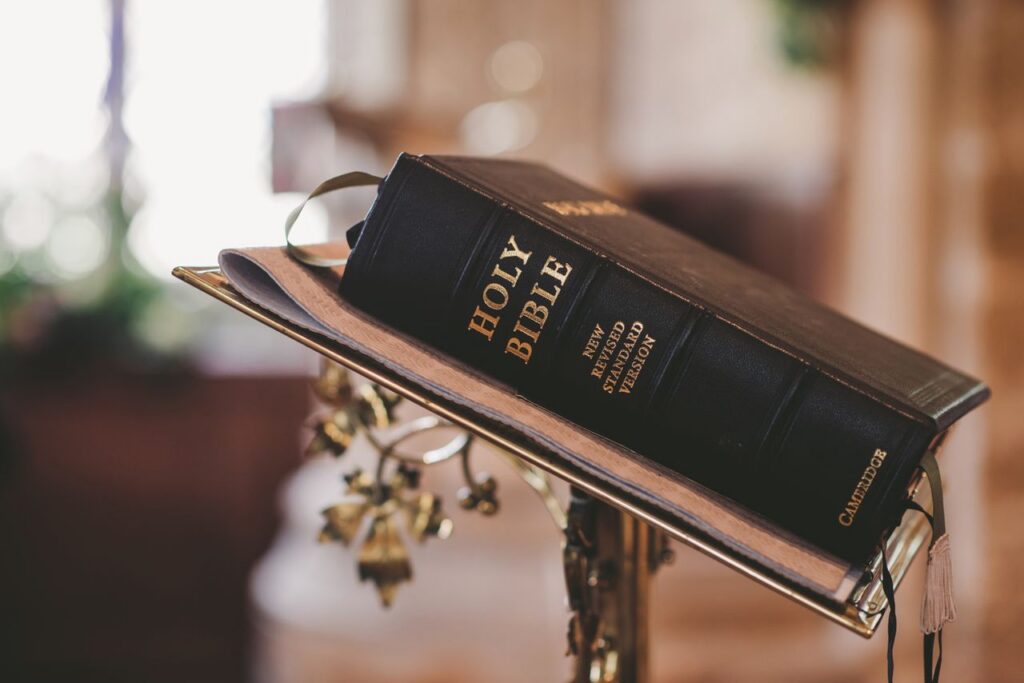 Holy Bible open on a stand inside a church, symbolizing faith and spirituality.